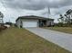 Charming single-story home featuring an attached two-car garage and a long paved driveway at 493 Omen St, Punta Gorda, FL 33982