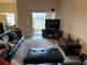 Inviting living room features a leather sofa, a large television, and sliding glass doors to the exterior at 493 Omen St, Punta Gorda, FL 33982