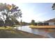Scenic backyard view of waterfront property showcasing lush lawn and home at 5565 Salem Square N Dr, Palm Harbor, FL 34685