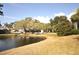 Scenic view of a backyard pond surrounded by lush landscaping and mature trees at 5565 Salem Square N Dr, Palm Harbor, FL 34685