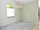 Empty room featuring a chandelier and an arched window at 5565 Salem Square N Dr, Palm Harbor, FL 34685