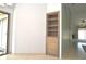 A hallway featuring built-in shelving and views into a bright, airy living space at 5565 Salem Square N Dr, Palm Harbor, FL 34685