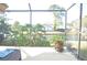 Relaxing screened-in porch overlooking a serene pond with lush greenery at 5565 Salem Square N Dr, Palm Harbor, FL 34685
