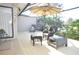 Comfortable screened porch featuring wicker furniture, umbrella, and a pond view at 5565 Salem Square N Dr, Palm Harbor, FL 34685