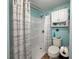 Bathroom with a shower stall, toilet, overhead storage and aqua walls with nautical accents at 117 S Saint Thomas Cir, Apollo Beach, FL 33572