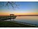 Tranquil lake view with private dock under a colorful sunset sky, perfect for evening relaxation at 10532 94Th Pl, Seminole, FL 33772