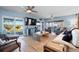 Relaxing living room featuring modern decor, wood flooring, and serene water views through expansive sliding doors at 10532 94Th Pl, Seminole, FL 33772