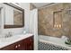Bathroom featuring stylish tub and shower with tile surround and cherry vanity at 156 29Th N Ave, St Petersburg, FL 33704