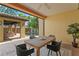 Inviting covered patio with a wooden table, seating area, and a view of the sparkling pool surrounded by lush landscaping at 156 29Th N Ave, St Petersburg, FL 33704