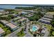 An aerial view of the property featuring the buildings, parking, pool, and landscaping near the bay and highway at 205 S Mcmullen Booth Rd # 202, Clearwater, FL 33759