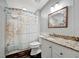 This bathroom features a shower with decorative curtain, granite vanity, and bright lighting at 206 S Port Royal Ln, Apollo Beach, FL 33572