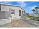 Exterior shot with brick accents and a well-maintained yard with patio access and staircase at 206 S Port Royal Ln, Apollo Beach, FL 33572