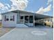 Charming single-story home with a covered carport and a decorative manatee design on the driveway at 206 S Port Royal Ln, Apollo Beach, FL 33572