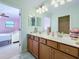 The bathroom is decorated in light greens and features a double vanity with wood cabinets at 6467 Willowshire Way, Bradenton, FL 34212