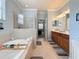 Luxurious bathroom featuring a glass-enclosed shower, soaking tub, double vanity, and elegant tile flooring at 6467 Willowshire Way, Bradenton, FL 34212