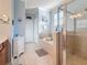 Well-lit bathroom featuring a soaking tub, glass-enclosed shower, and linen storage at 6467 Willowshire Way, Bradenton, FL 34212