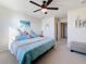 This bedroom includes a ceiling fan, beach-themed art, decor and bedding and a bench by the door at 6467 Willowshire Way, Bradenton, FL 34212