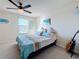 A cozy bedroom features a queen bed with decorative pillows and bedding and a guitar by the wall at 6467 Willowshire Way, Bradenton, FL 34212