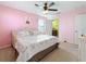 This pink bedroom contains a ceiling fan, a Paris-themed bed, a chest of drawers and an adjoining bathroom at 6467 Willowshire Way, Bradenton, FL 34212
