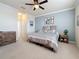 Spacious bedroom with a ceiling fan, carpeted floors and a decorative accent wall with a king-size bed at 6467 Willowshire Way, Bradenton, FL 34212
