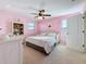 This bedroom is painted pink and has a ceiling fan above a bed with a decorative white frame and teddy bear at 6467 Willowshire Way, Bradenton, FL 34212