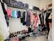A walk-in closet includes rods for hanging clothing and shelves for shoes and storage containers at 6467 Willowshire Way, Bradenton, FL 34212