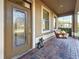 The front door is glass and has a porch swing, and is located on a brick walkway at 6467 Willowshire Way, Bradenton, FL 34212