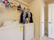 A laundry room contains a washer and dryer, shelves of detergents and cleaning supplies, and hanging clothes at 6467 Willowshire Way, Bradenton, FL 34212