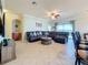 Spacious living room featuring neutral tile flooring, a comfortable sectional sofa, and a ceiling fan at 6467 Willowshire Way, Bradenton, FL 34212