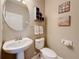 Charming powder room featuring a pedestal sink, neutral walls and decorative nautical-themed artwork and shelving at 6467 Willowshire Way, Bradenton, FL 34212