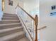 Carpeted staircase with white banisters and stained wood accents provides a view into the living room below at 6467 Willowshire Way, Bradenton, FL 34212