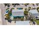 Aerial view of a cozy blue house with a private pool and lush landscaping, nestled in a serene neighborhood at 308 2Nd St N # 202, Bradenton Beach, FL 34217
