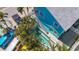 Aerial view of the property, showcasing the pool, colorful exterior, landscaping, and proximity to nearby parking at 308 2Nd St N # 202, Bradenton Beach, FL 34217
