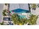 Aerial view of turquoise beach house with pool, palm trees, outdoor furniture and parking at 308 2Nd St N # 202, Bradenton Beach, FL 34217