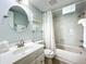 Well-lit bathroom showcasing a circular mirror, and a shower with a white shower curtain at 308 2Nd St N # 202, Bradenton Beach, FL 34217