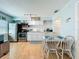 Clean white kitchen with stainless steel appliances, dining table, and hardwood floors offers a modern aesthetic at 308 2Nd St N # 202, Bradenton Beach, FL 34217
