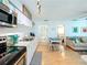 Open kitchen with white cabinetry and stainless steel appliances leads to cozy living area at 308 2Nd St N # 202, Bradenton Beach, FL 34217