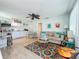 Bright open-plan living room with coastal decor, sofa, and modern ceiling fan flows into a modern kitchen at 308 2Nd St N # 202, Bradenton Beach, FL 34217