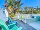 Lushly landscaped pool area with multiple seating options for relaxation, creating a serene and tropical retreat at 308 2Nd St N # 202, Bradenton Beach, FL 34217
