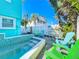 Private pool area showcasing colorful Adirondack chairs and lush, tropical landscaping offering a relaxing outdoor oasis at 308 2Nd St N # 202, Bradenton Beach, FL 34217