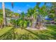 Lush backyard with tropical foliage, white rock landscaping, and screened in patio at 5501 E Longboat Blvd, Tampa, FL 33615