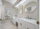 Bathroom featuring double sinks, marble countertops, and a large window for natural light at 5501 E Longboat Blvd, Tampa, FL 33615
