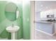 Powder room near kitchen features a pedestal sink and doorway view of the kitchen island at 7055 Summer Holly Pl, Riverview, FL 33578