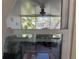 View through a window of an outdoor patio with chairs, rug and other household items at 8075 Gulf Blvd, St Pete Beach, FL 33706