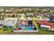Aerial view of home featuring a screened-in pool, fenced yard, and solar panels on the roof at 9229 Water Hazard Dr, Hudson, FL 34667