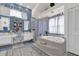 Elegant bathroom featuring a soaking tub, double vanities, tiled accents, and lots of natural light at 9229 Water Hazard Dr, Hudson, FL 34667