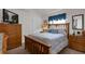 Warm bedroom featuring soft lighting, a full-size bed and wood furniture at 9229 Water Hazard Dr, Hudson, FL 34667