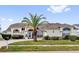 Stunning home featuring a well-manicured lawn, mature palm tree, and a grand entrance with an arched doorway at 9229 Water Hazard Dr, Hudson, FL 34667
