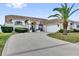 Beautiful single-story house with a wide driveway, attached two-car garage, and lush landscaping in a quiet neighborhood at 9229 Water Hazard Dr, Hudson, FL 34667