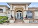 Inviting front entrance with double doors framed by columns and decorative lion statues on the porch at 9229 Water Hazard Dr, Hudson, FL 34667